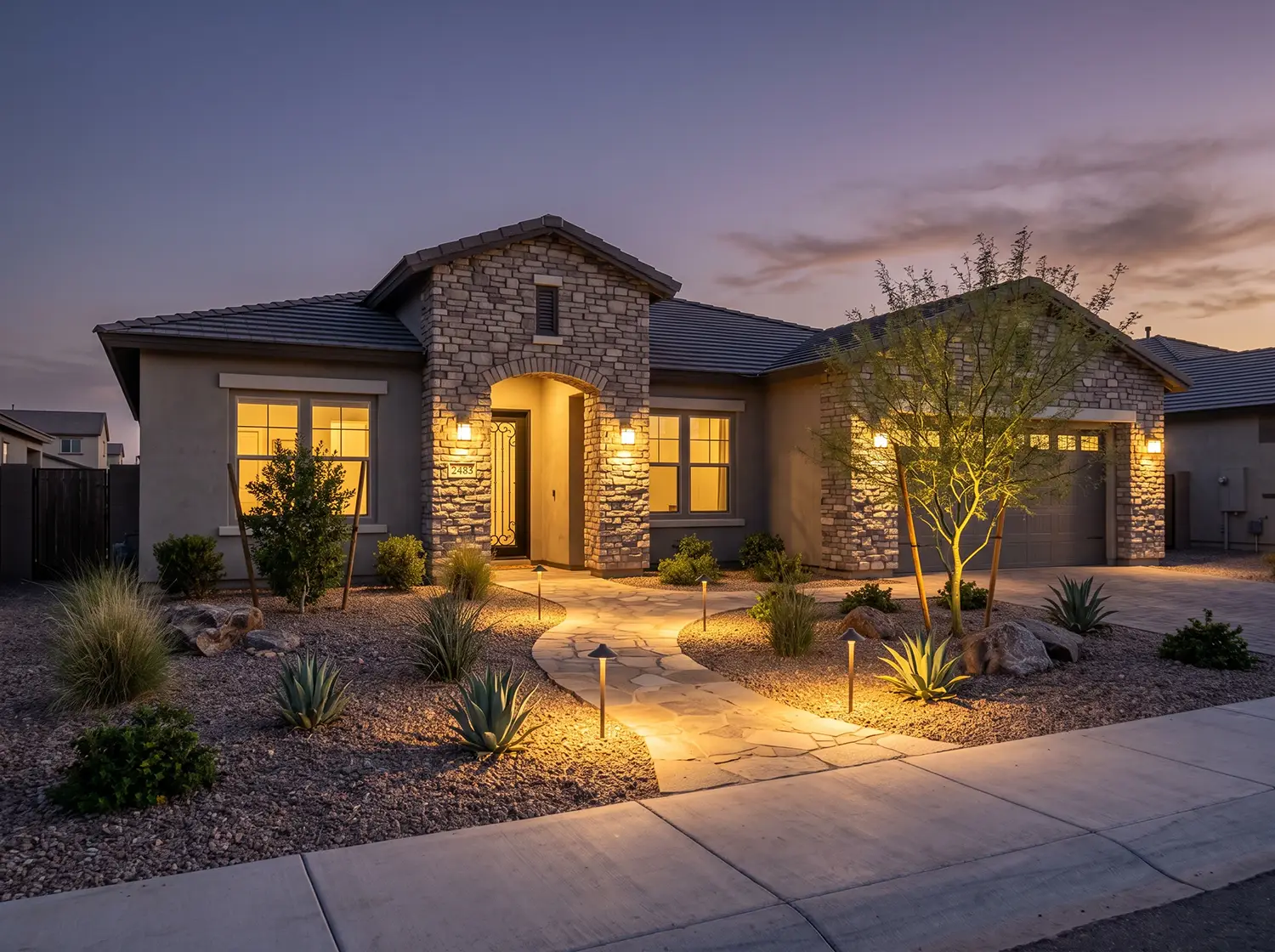 Desert landscape lighting on a Avondale, Arizona home with up-lit plants at night