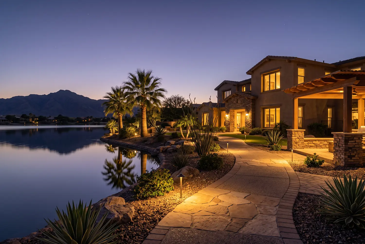Desert landscape lighting on a Goodyear, Arizona home with up-lit plants at night